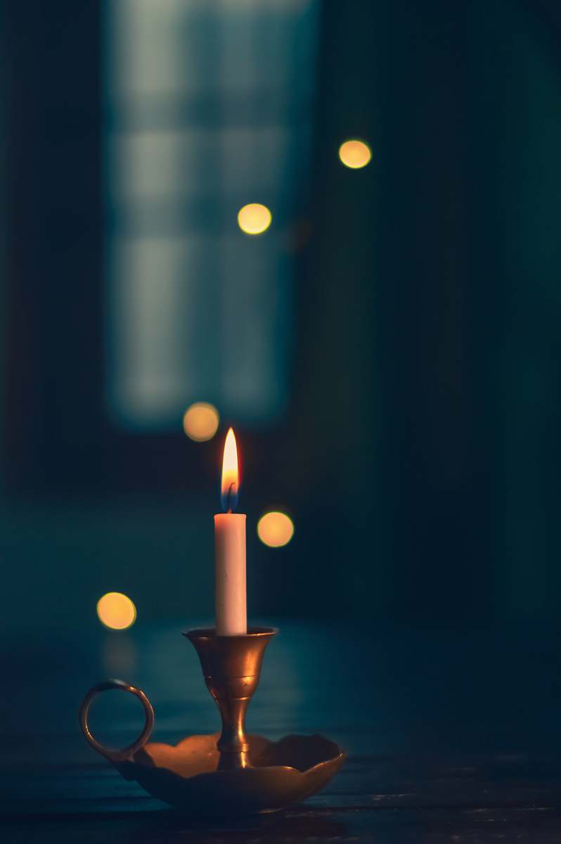 new delhi white candle lit on brass candle holder india